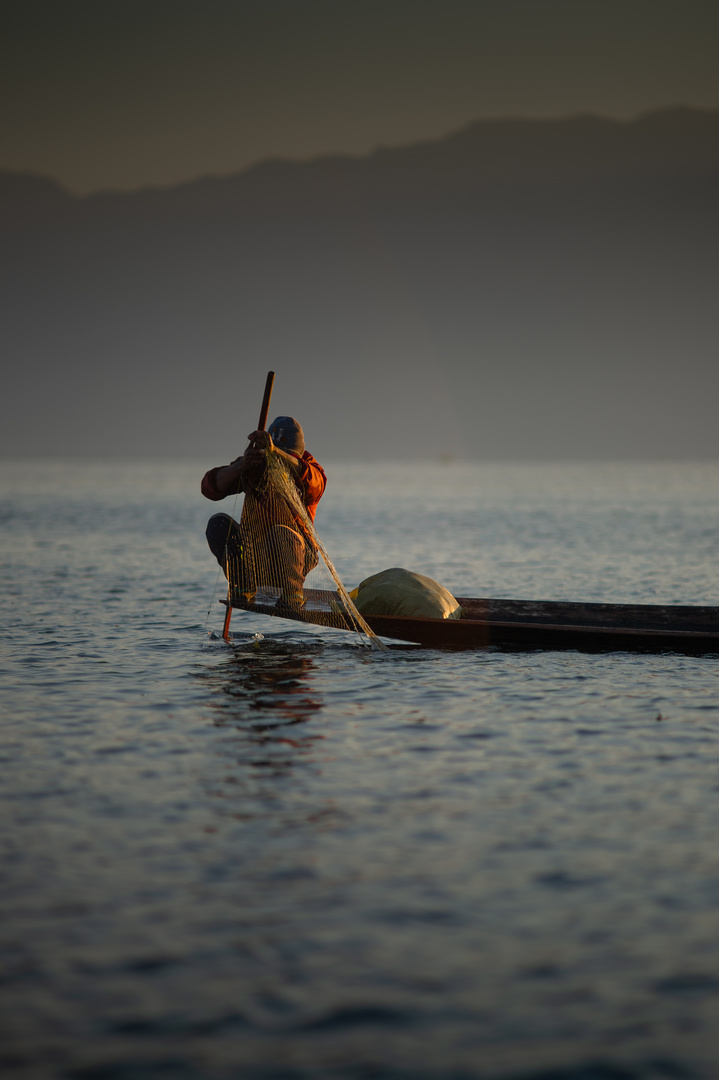 Fischer auf dem Bug seines Bootes auf dem Inle See