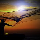 Fischer bei der Arbeit im Licht der untergehenden Sonne