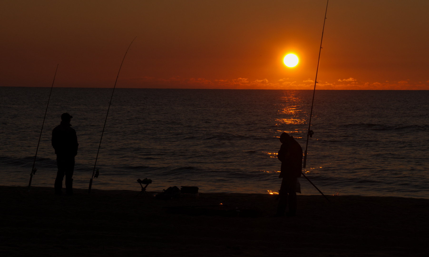 Fischer bei Sonnenuntergang am Meer