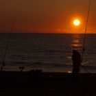 Fischer bei Sonnenuntergang am Meer