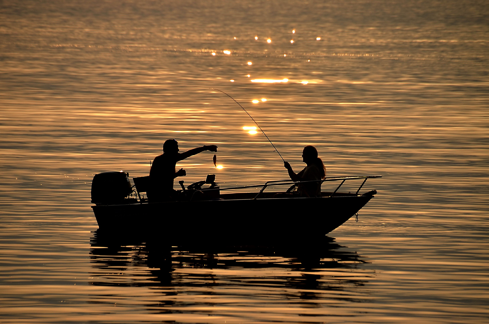 Fischer beim Angeln in der Abenddämmerung am Lago Maggiore