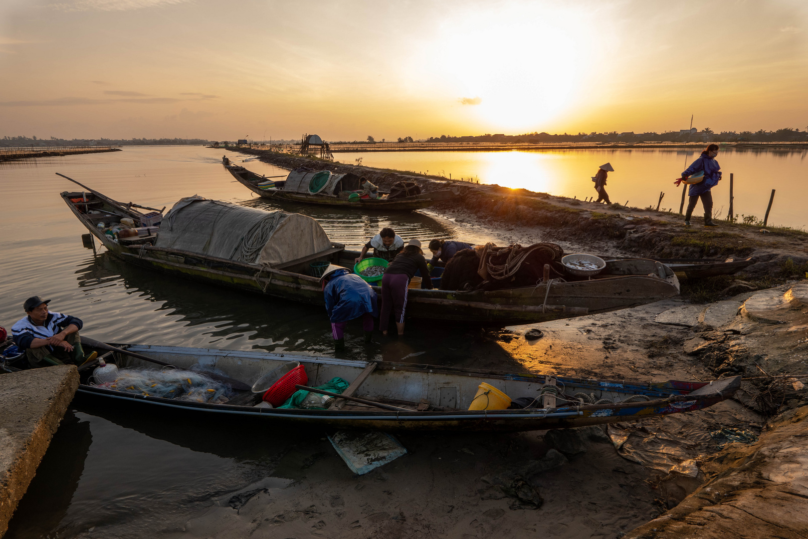 Fischer die am frühen Morgen ihren Fang in der Tam Giang Lagune bei Hue Vietnam anlanden