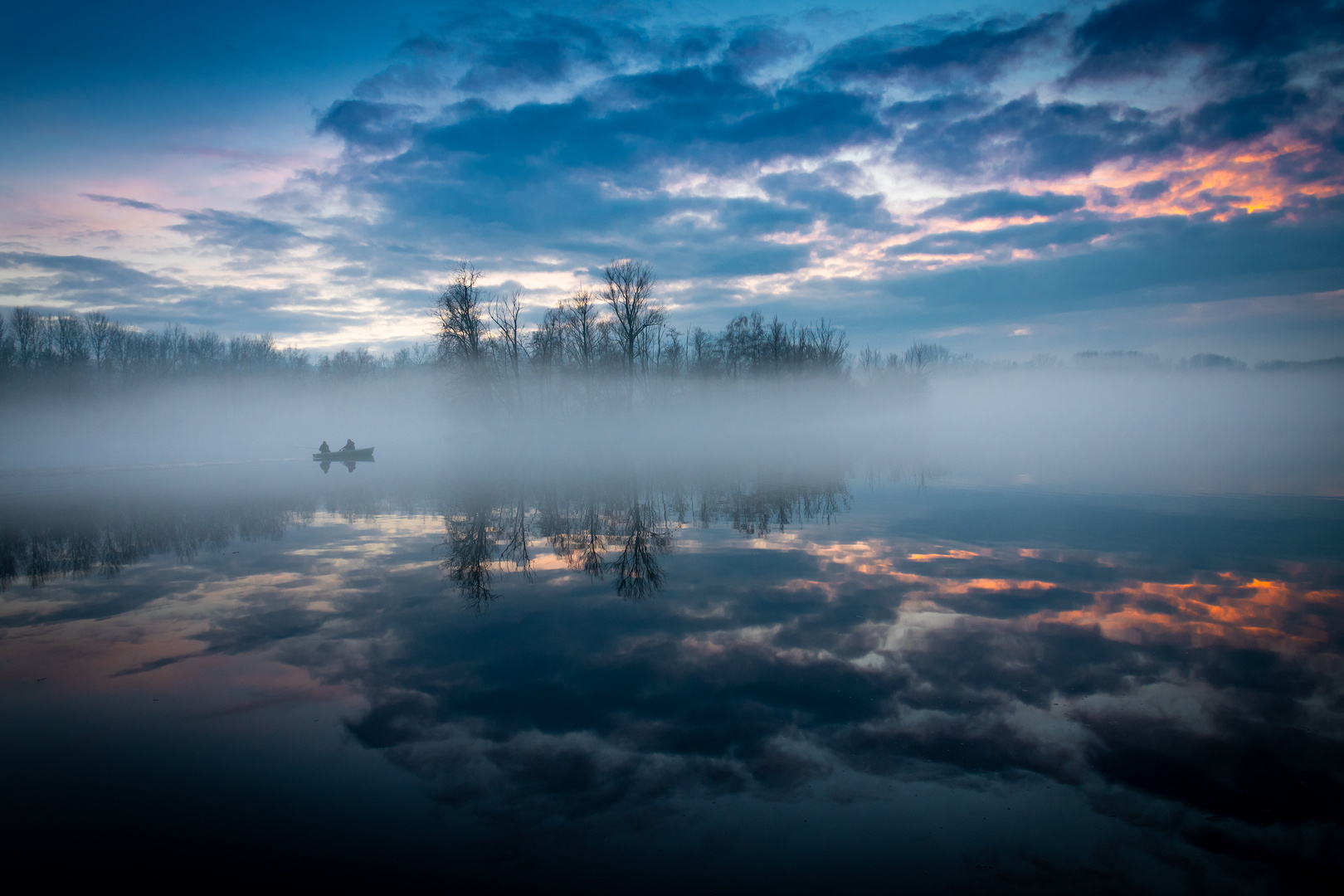 Fischerboot im Morgennebel auf der Donau