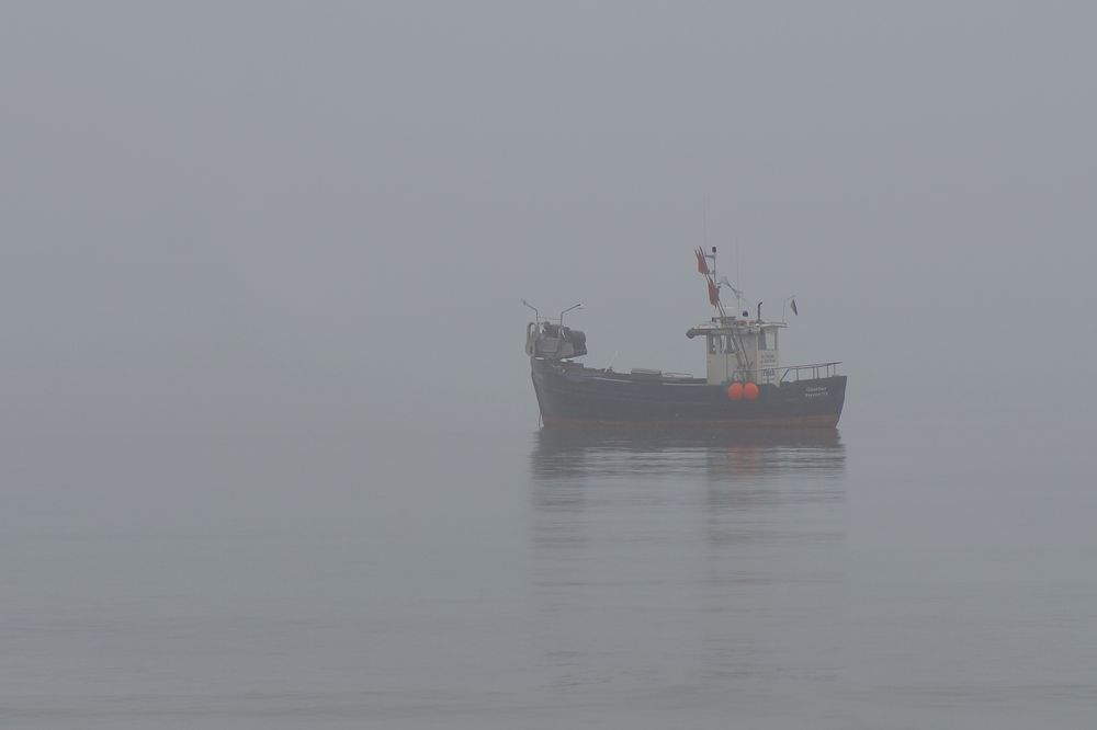 Fischerboot im Nebel