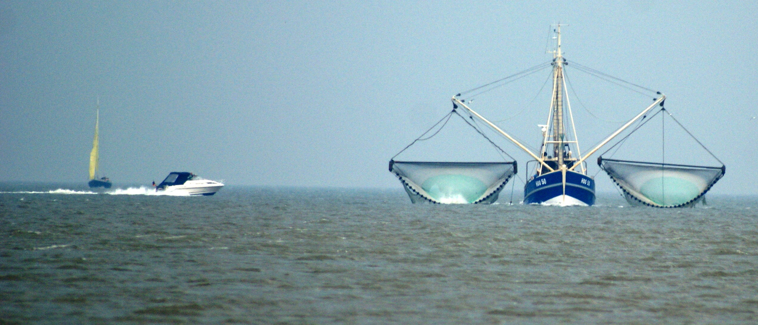 Fischerboot in Begleitung.