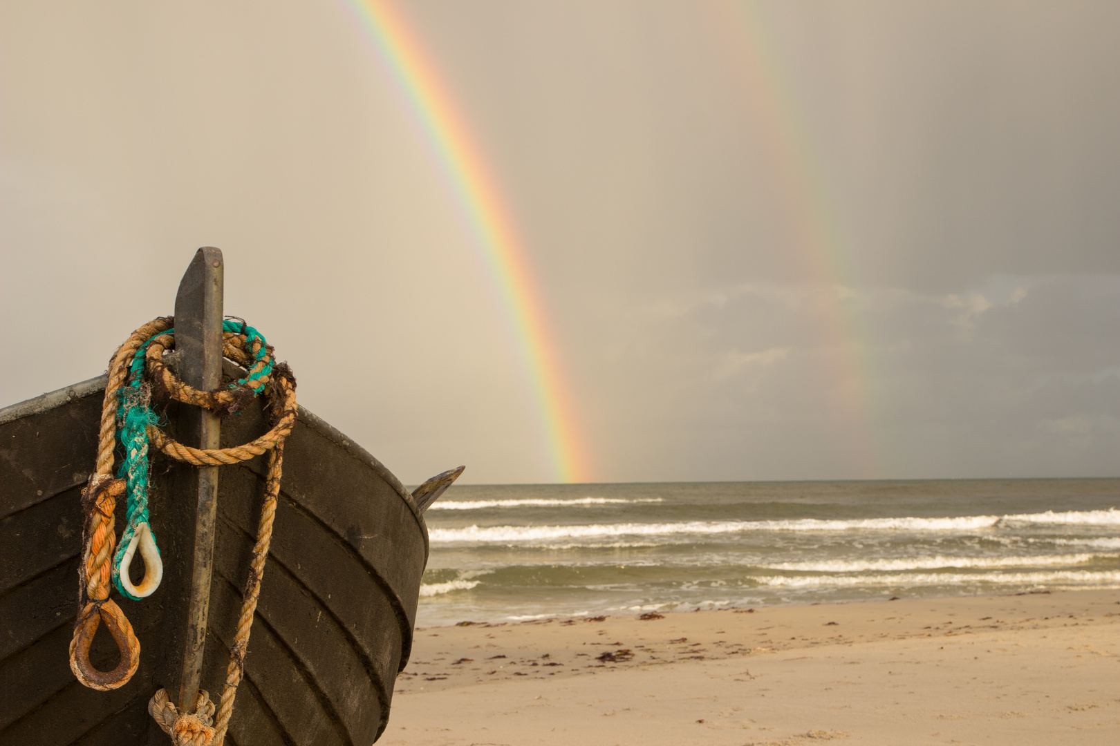 Fischerboot mit schillerndem Regenbogen