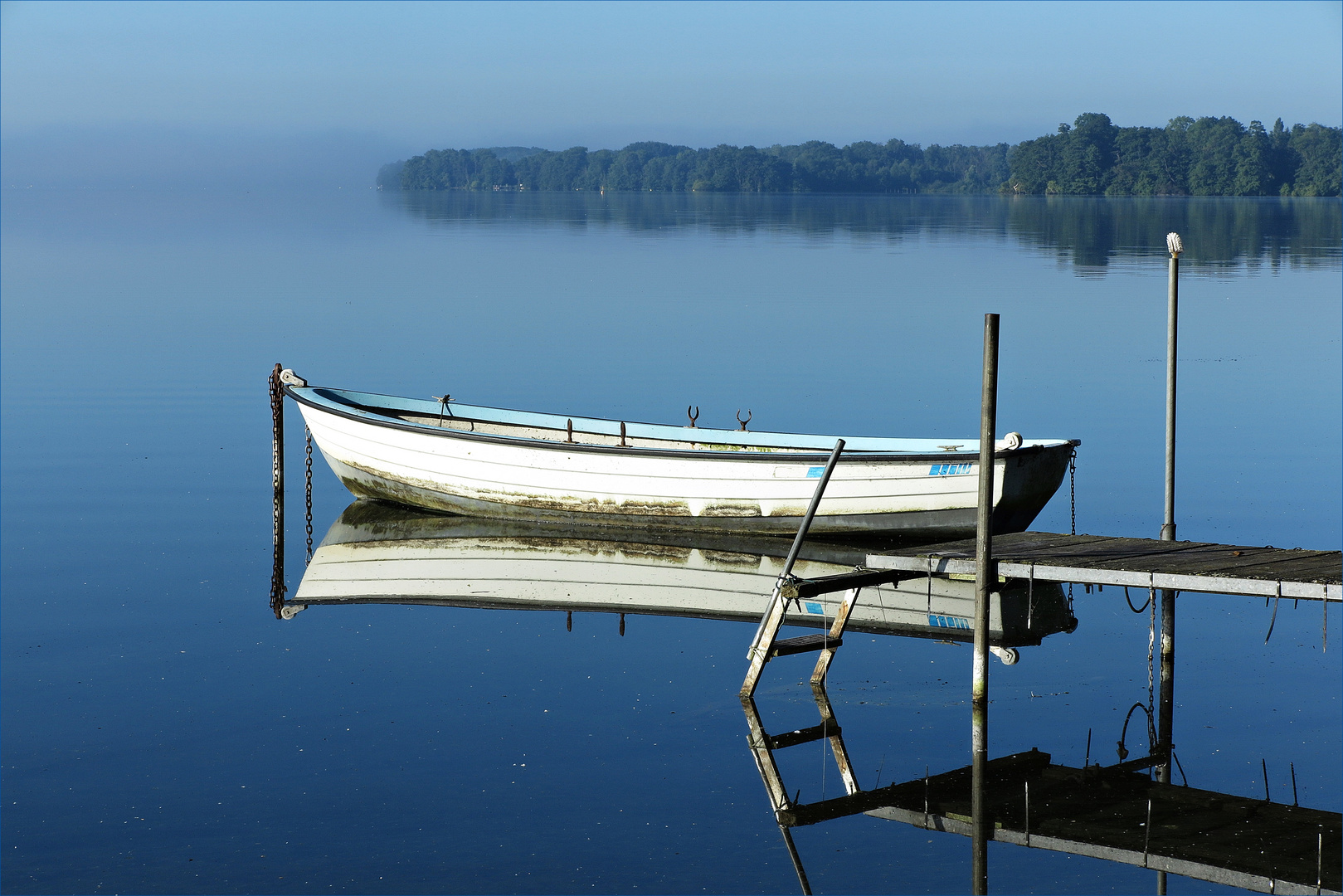 Fischerboot spiegelt sich im Großen Plöner See