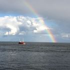 Fischerboot unter dem Regenbogen