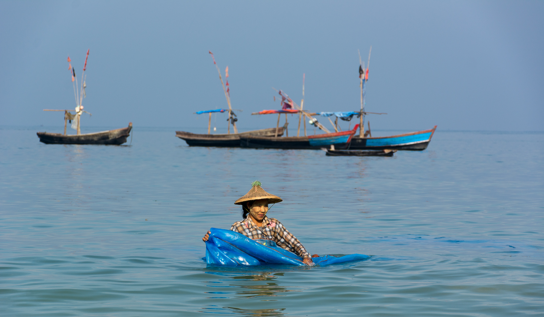 Fischersfrau beim Waschen der Netze. Ngapali Beach Myanmar