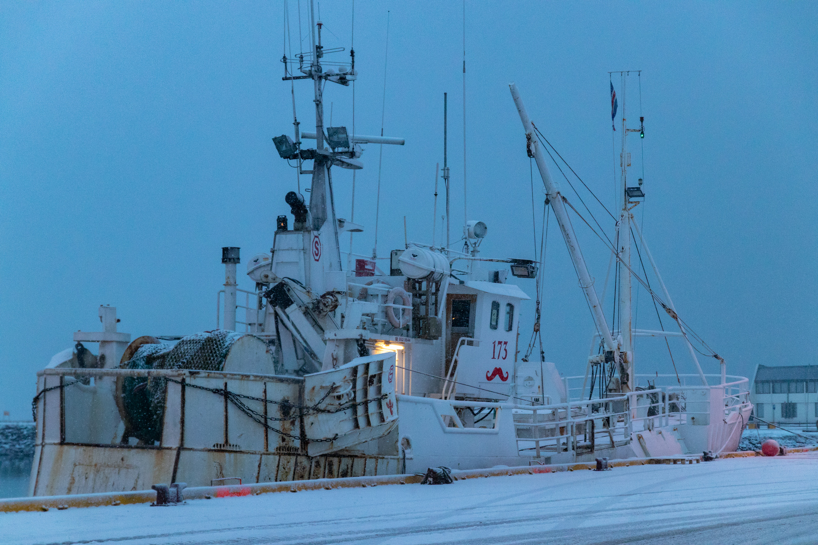 Fischkutter abends bei Schneefall in Höfn