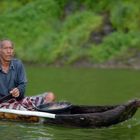 Fisherman goes out in a dugout canoe nearby Trunyan