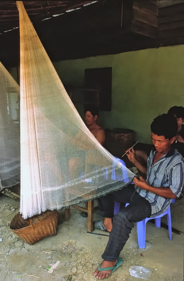 Fisherman repairs his net