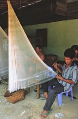 Fisherman repairs his net