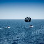 Fliegen an einem Fallschirm hinter einem Boot auf einen Urlaub am Meer 