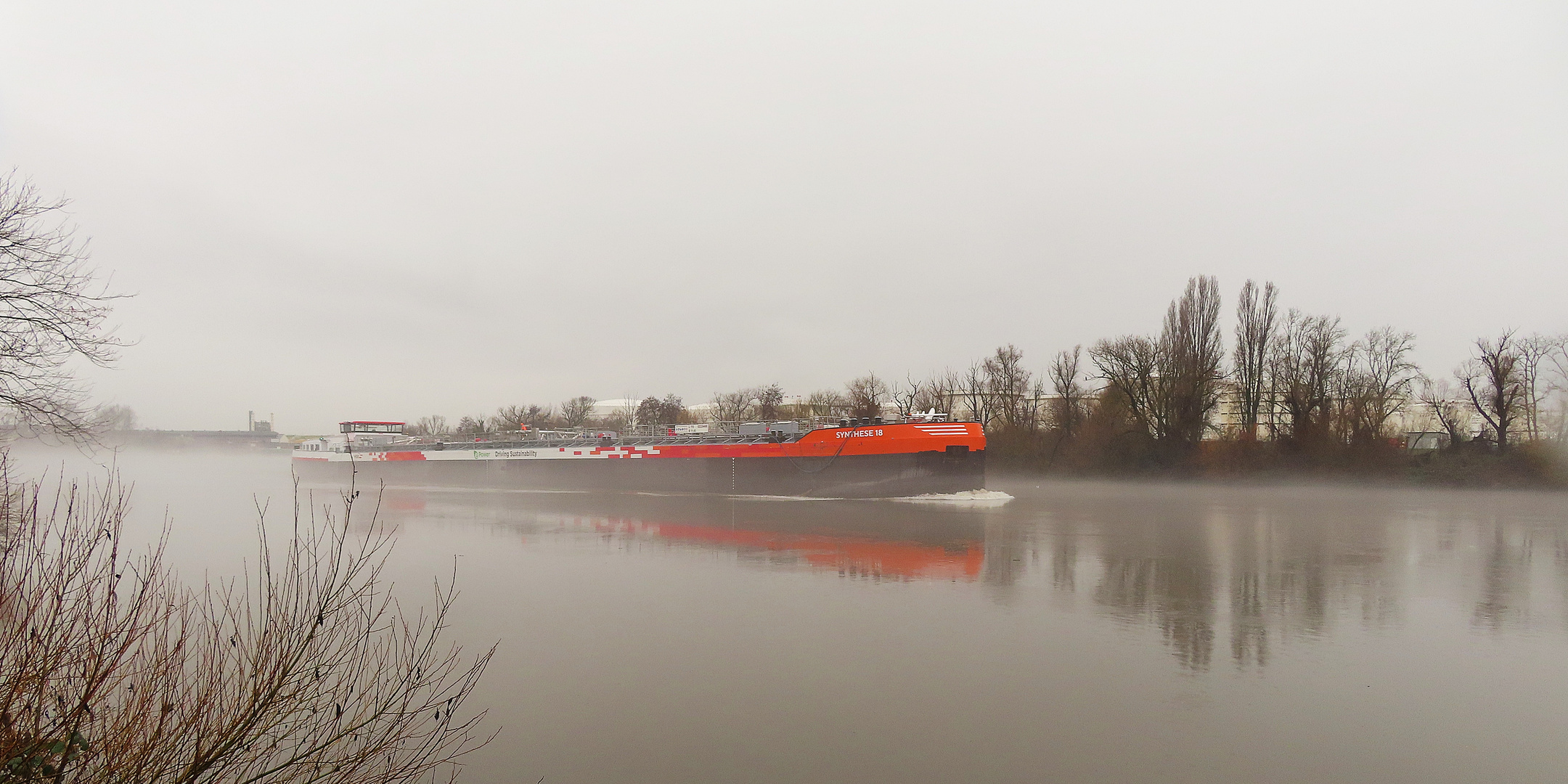 Flusslandschaft bei Nebel und Regen