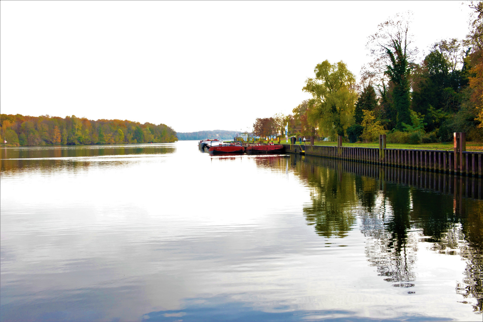 Flusslandschaft im Herbst mit roten Leichtern