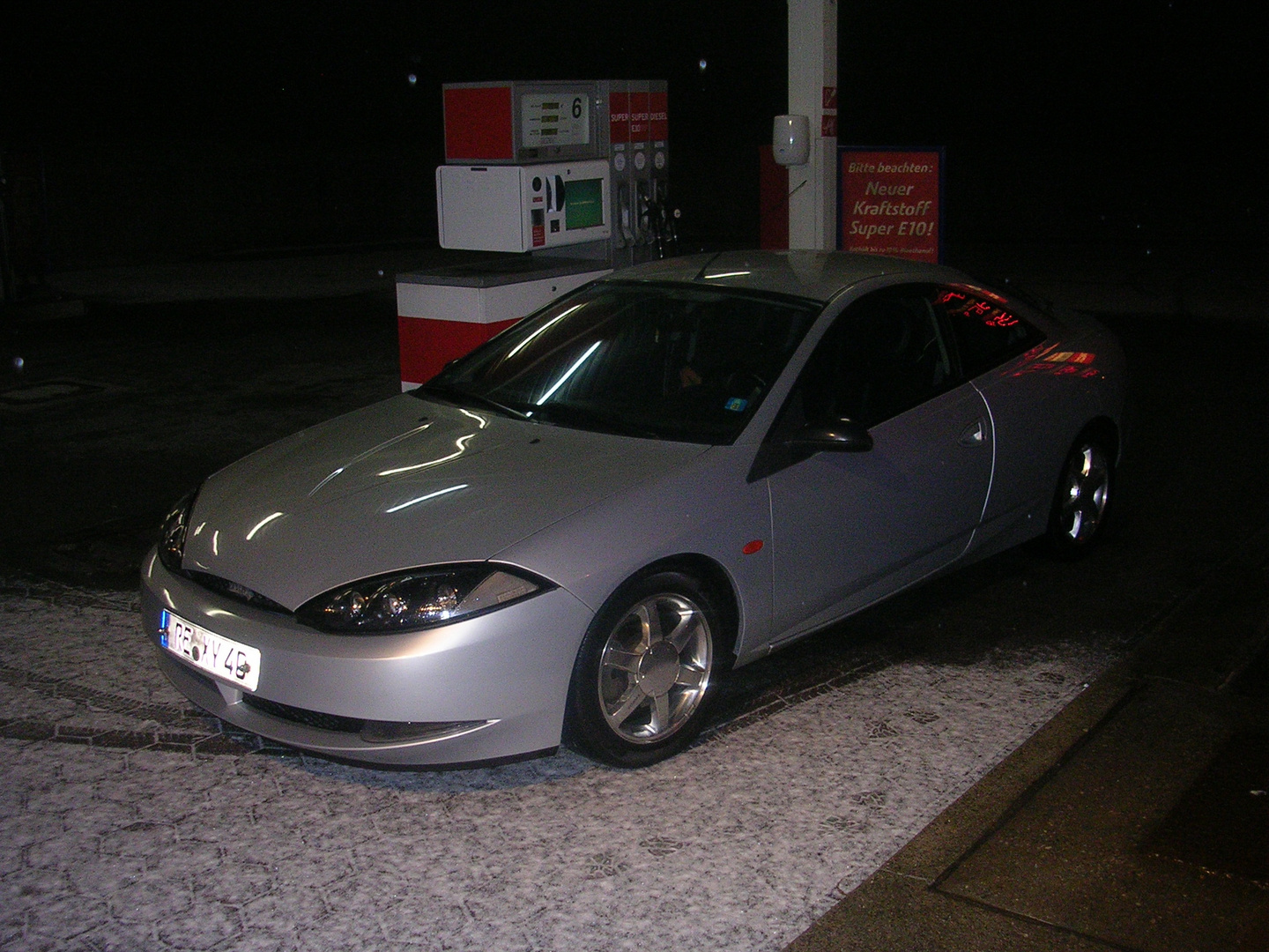 Ford Cougar bei Nacht an der Tanke