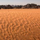 Fragile Sand-Creation vor schwarzbraunen Felsen