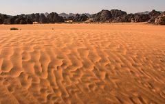 Fragile Sand-Creation vor schwarzbraunen Felsen