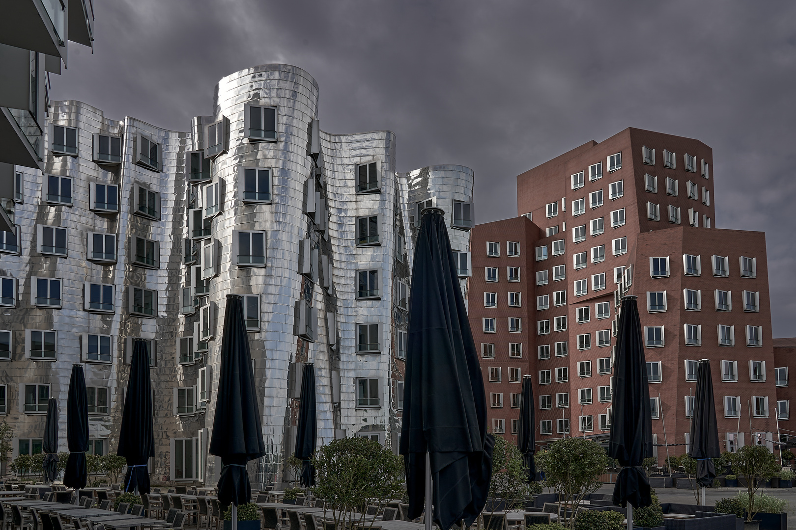 Frank Gehry - Häuser mit Sonnenschirmen im Regen