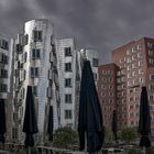 Frank Gehry - Häuser mit Sonnenschirmen im Regen