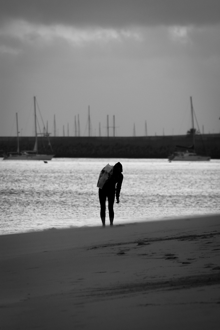 Frau am Strand vor Hafen