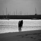 Frau am Strand vor Hafen