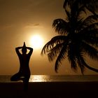 Frau macht Yoga am Strand