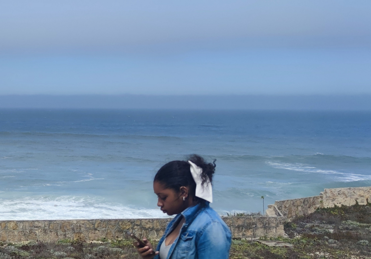 Frau mit Handy am Meer 