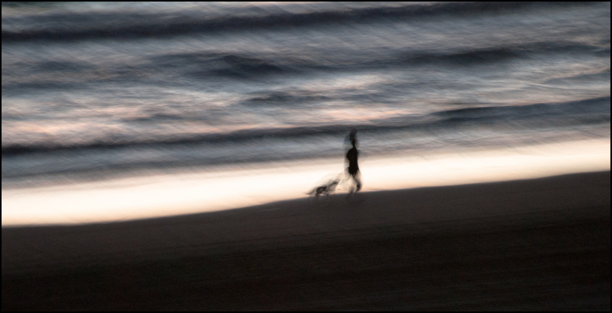 Frau mit Hund abends am Meer