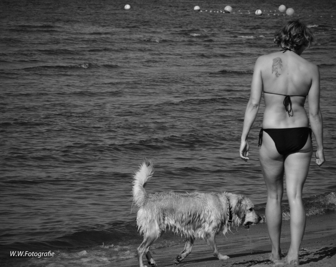 Frau mit Hund am Strand in schwarz/weiß