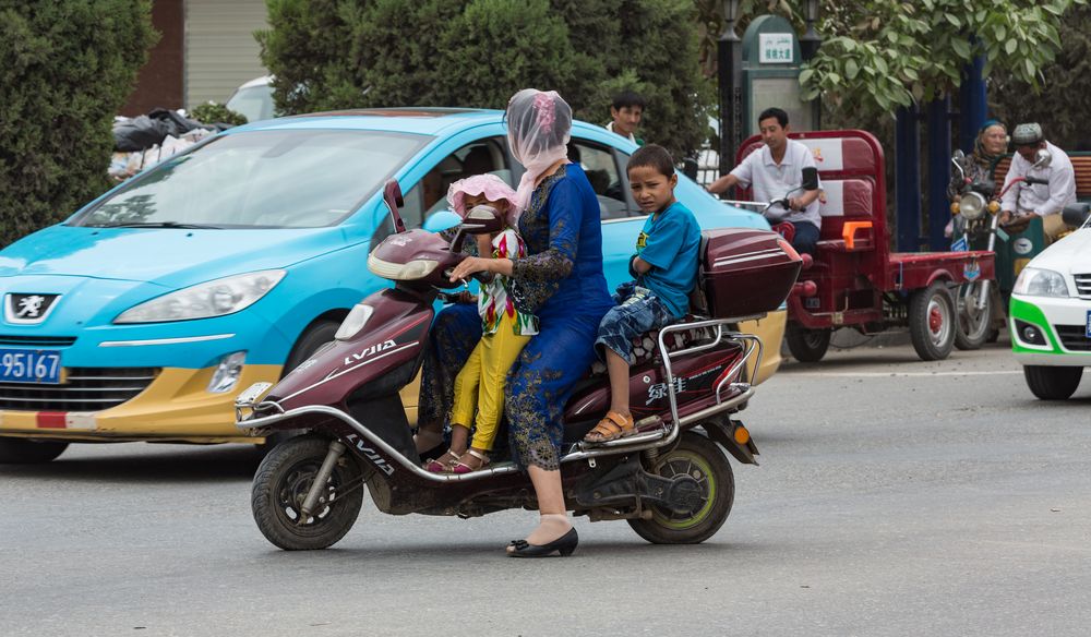 Frau mit Kindern auf Roller...