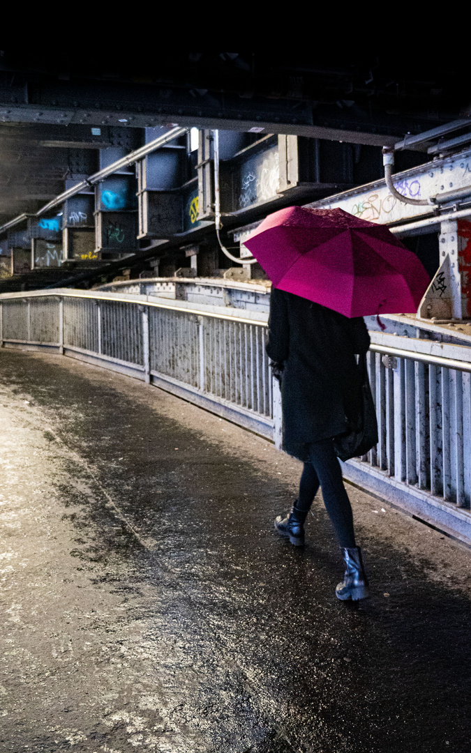 Frau mit Regenschirm am Bahnhof Friedrichstrasse