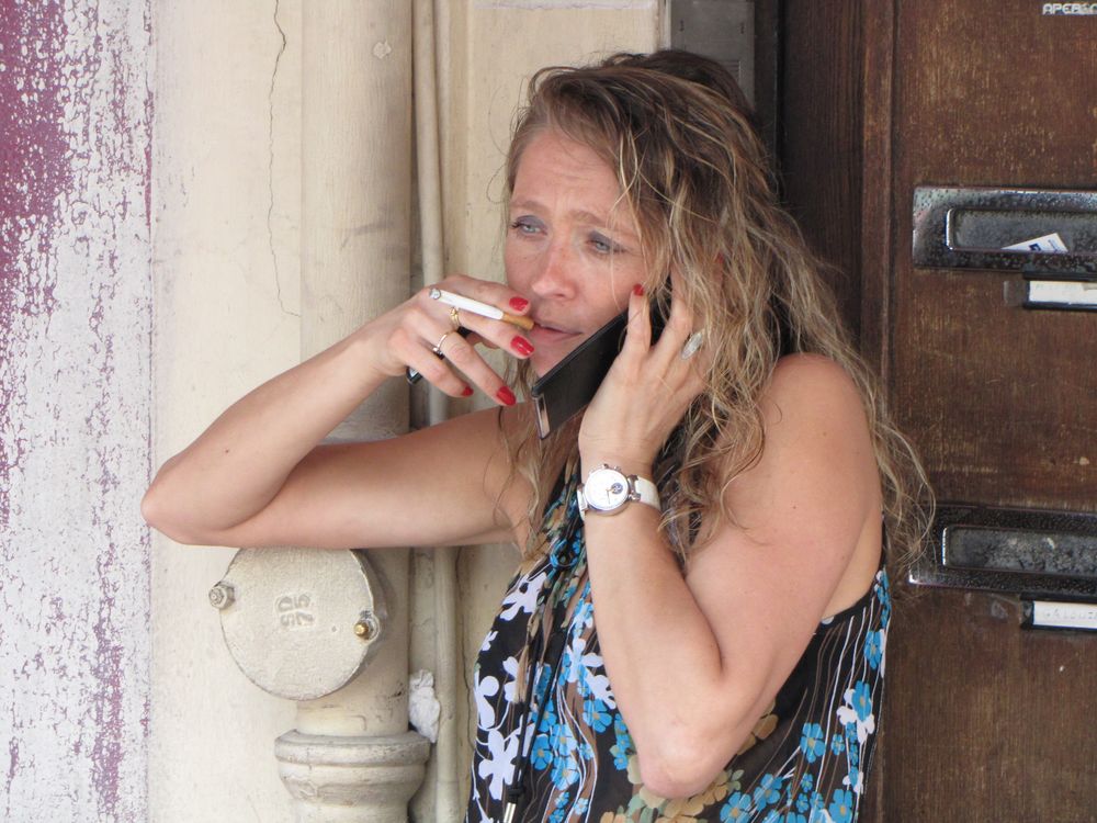 Frau mit  Zigarette und Handy.