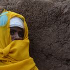 Frau neben einem Gebetsstock vor der Erlöserkirche in Lalibela