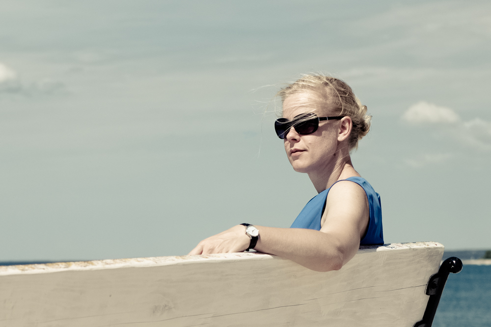 Frau, sitzend mit Sonnenbrille im Sommer