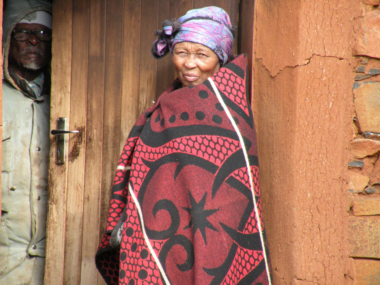 Frau vor ihrem Haus im Hochland von Lesotho