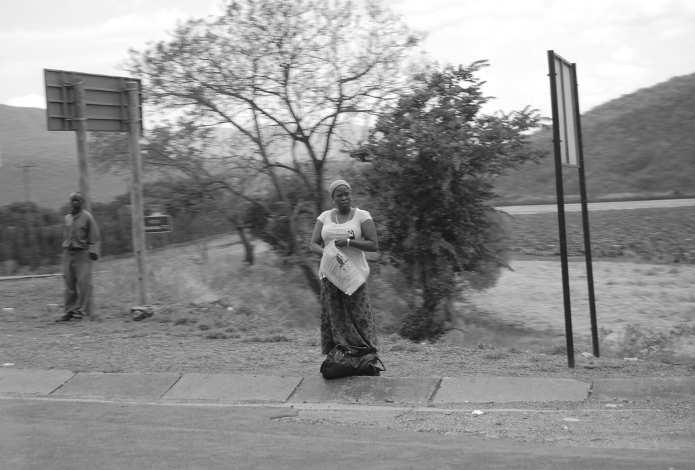 Frau wartet an der Straße (Südafrika)