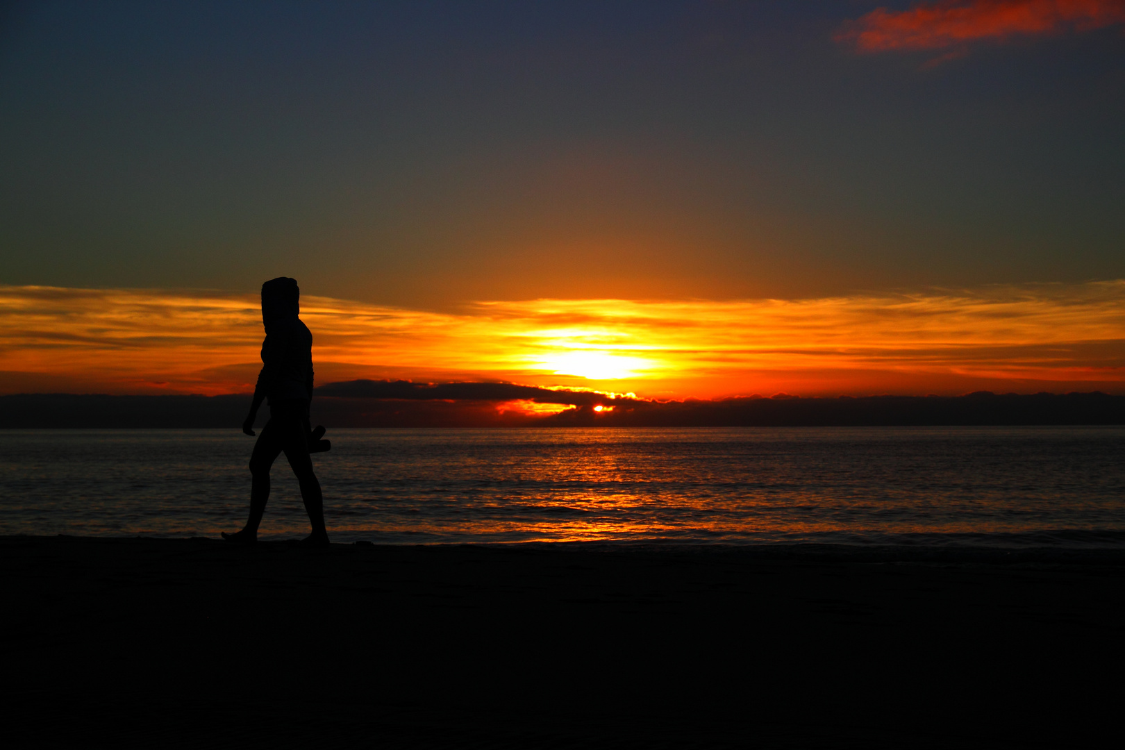 Früh am Morgen am Strand (Sonnenaufgang mit Jogger)