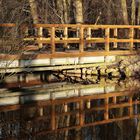 Früh morgens spiegelt sich die kleine Brücke 