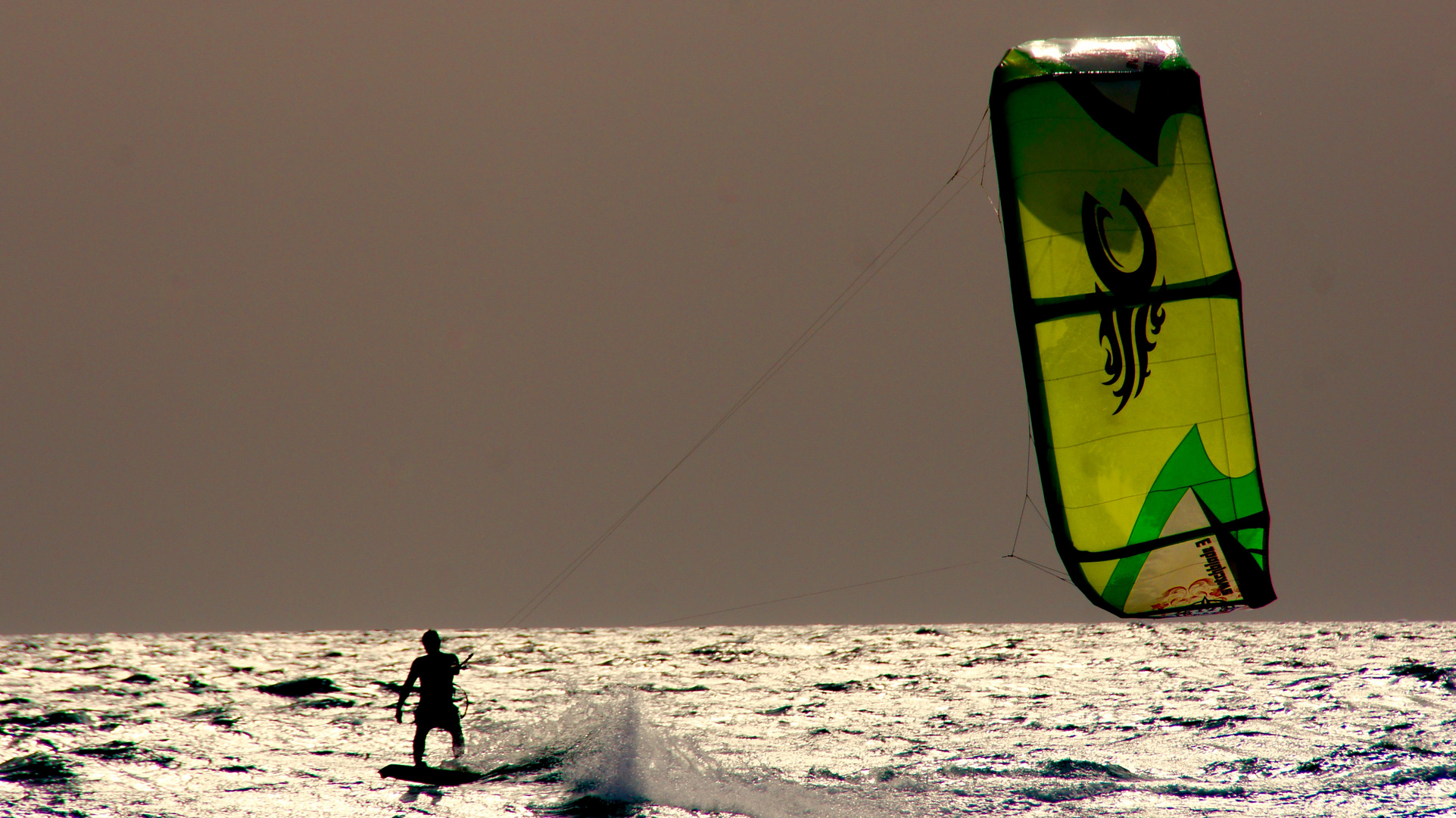 ganz lässig gleitet der Kitesurfer über die Wellen der Playa de Sotavento 