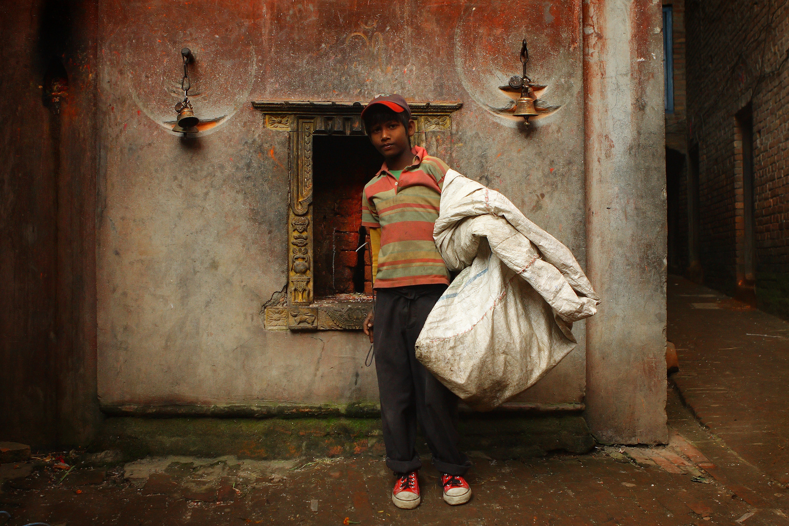 Garbage Boy standing against the wall of the temple.