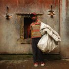 Garbage Boy standing against the wall of the temple.