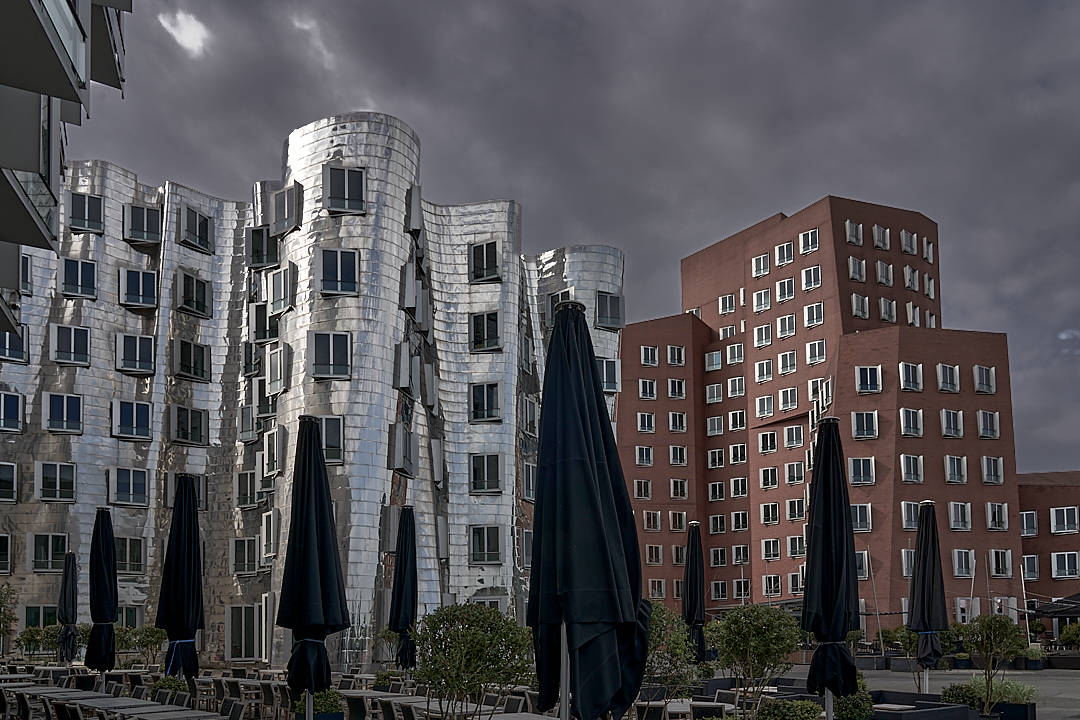 Gehry-Bauten mit Sonnenschirmen im Regen