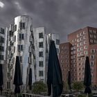 Gehry-Bauten mit Sonnenschirmen im Regen