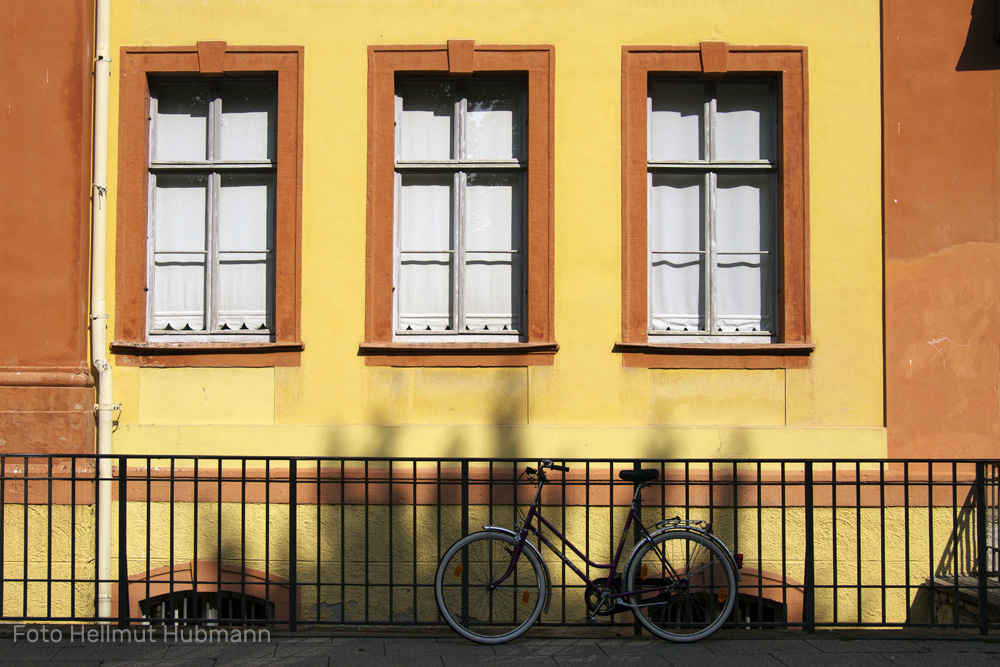 GELBE FASSADE MIT GITTER UND FAHRRAD