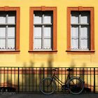 GELBE FASSADE MIT GITTER UND FAHRRAD