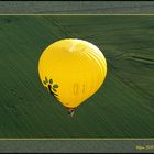gelber Ballon über grünem Feld