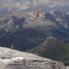 Genussvoller Flug eines Drachenfliegers am Piz Boe mit Blick zur Bergstation des Sass Pordoi