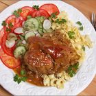 Geschmorte Schweineschulter mit Salat und Nudeln